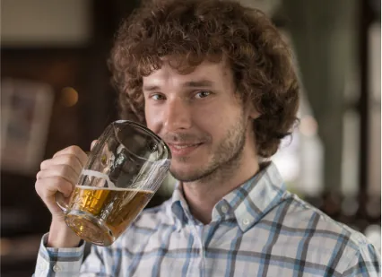 reasons why people drink alcohol featured image with a man drinking beer