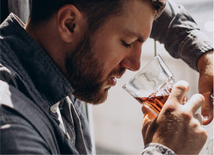 What is Alcohol Withdrawal Fever? featured image with a man drinking alcohol