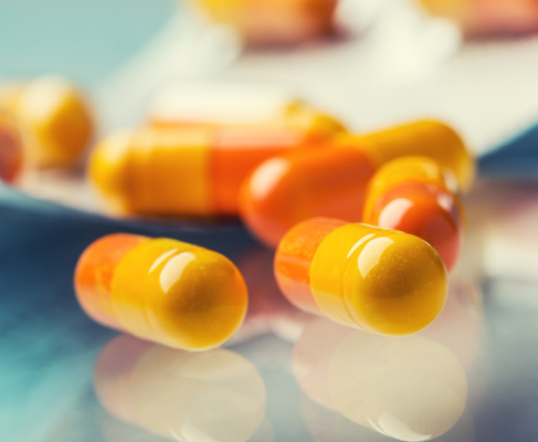 A several yellow-orange pills as a symbol of mixing alcohol and codeine