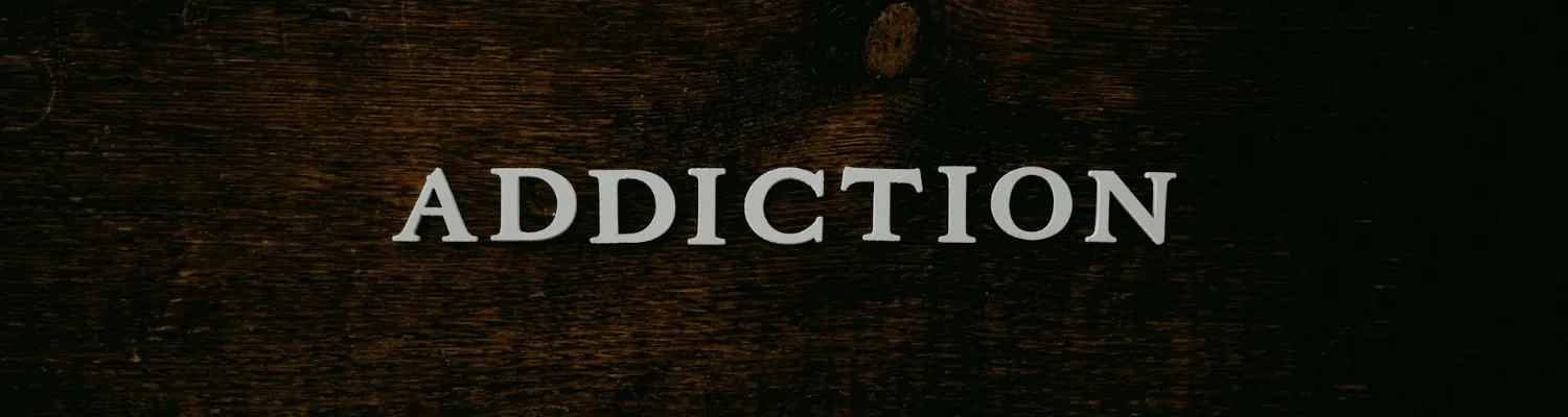 The word ADDICTION in white on a black surface for people who are addicted to alcohol and codeine. 