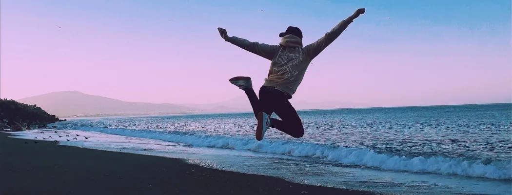 A person jumping while looking at the ocean