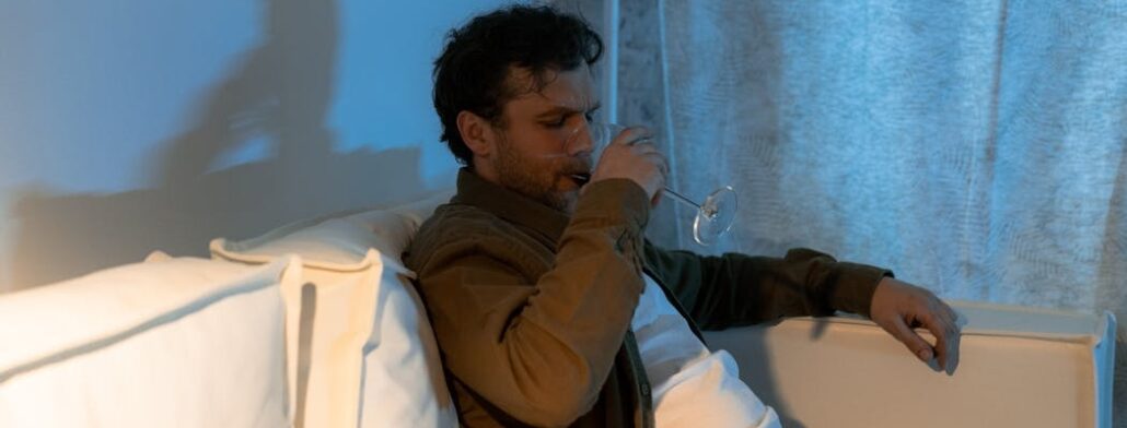 A depressed person drinking wine, which is a situation that requires dual diagnosis treatment