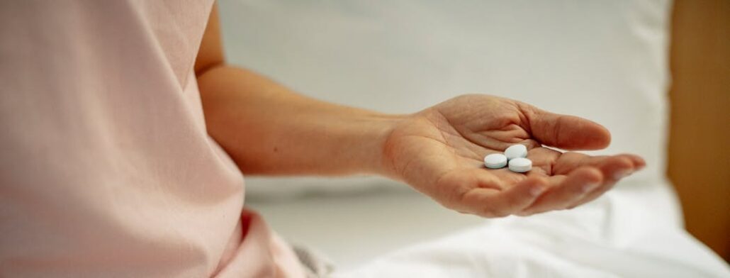 A person holding pills in their hand