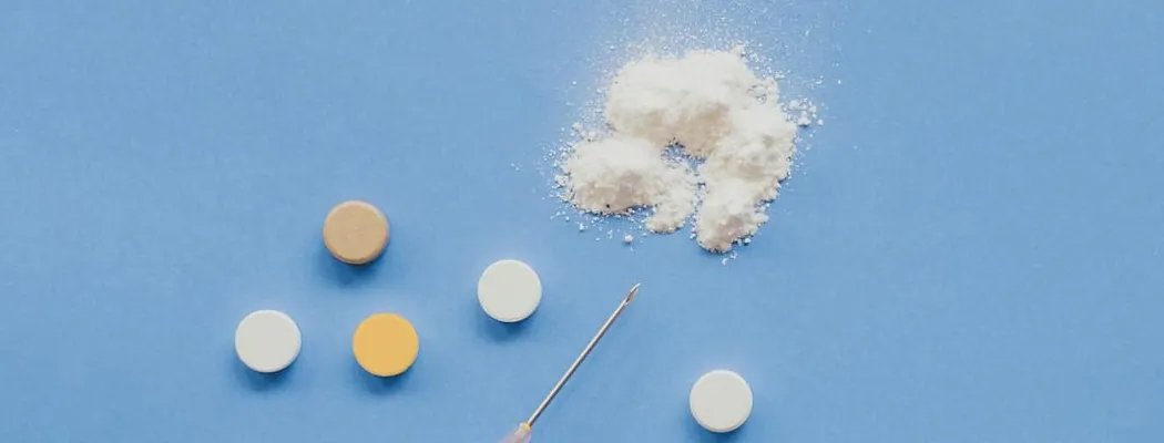 Pills and white powder on a blue background