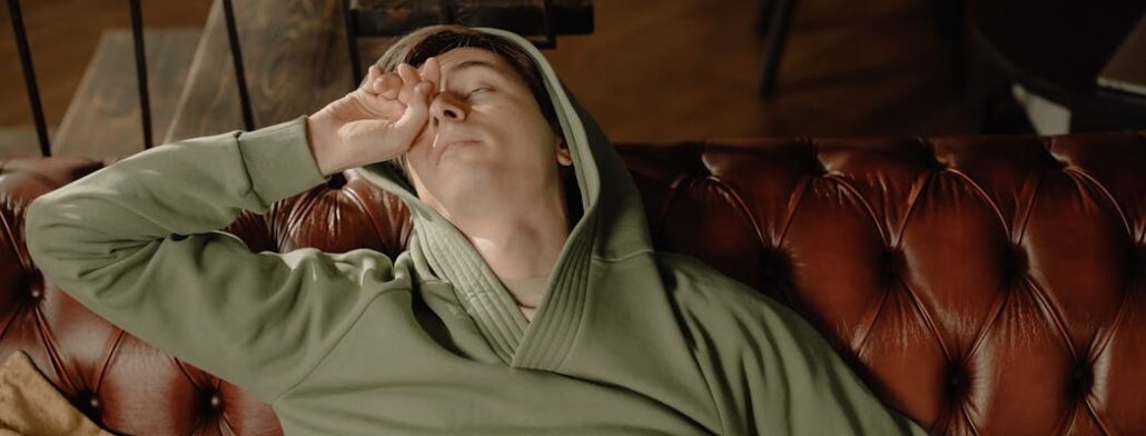 A person on the couch showing lack of energy, which is a sign they need help from a heroin detox Florida center